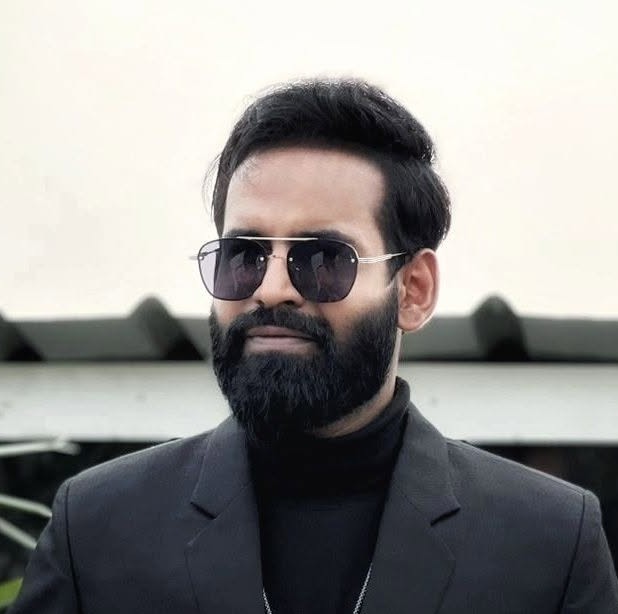 Shamim Rahman Sam wearing a black suit and sunglasses